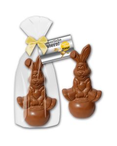 Osterhase hüpfend auf Ball als witzige Schokoladenfigur mit Gymnastikball als Hase zu Ostern